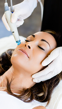 woman smiling as she receives a HydraFacial service